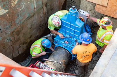 Team EJP installing an AVT EZ Valve in Westfield, MA - four team members in the trench with the valve